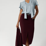 This women's workwear midi skirt in a stunning wine colour is made from a luxe, easy-care Scuba Crepe Jersey fabric, offering a soft textured feel and full body stretch for comfort and flexibility throughout your day.