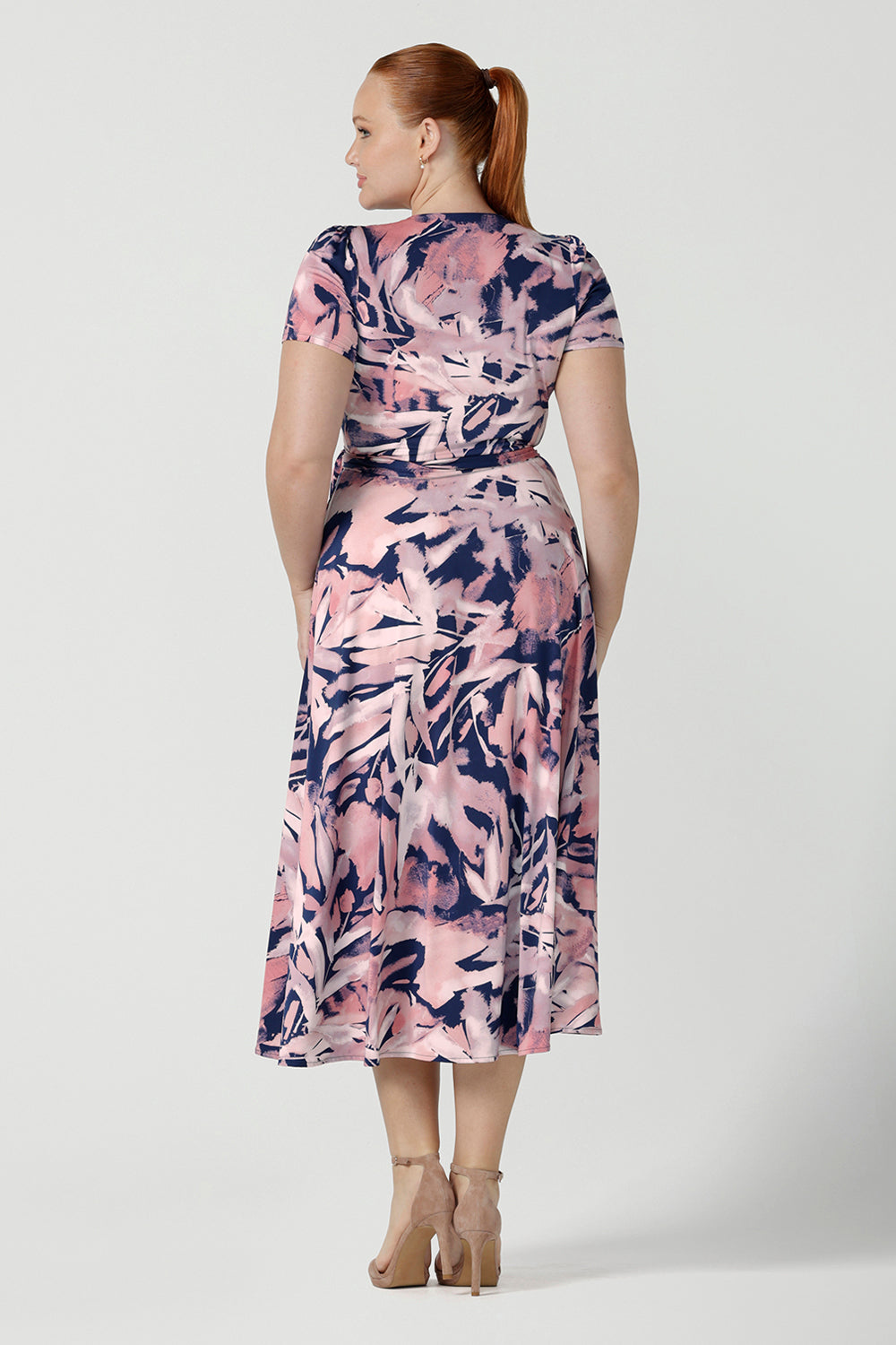 Back view of a size 12 woman wearing the Alexis dress a functioning wrap dress with short sleeve and midi length. Great for work to weekend wear. Made in Australia for women size 8 - 24.