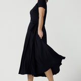 An over 40, size 10 woman wearing a navy, wrap dress with short sleeves. A great dress for summer casual wear, or for travel. Shop made in Australia dresses in petite to plus sizes online at Australian fashion brand, Leina & Fleur.