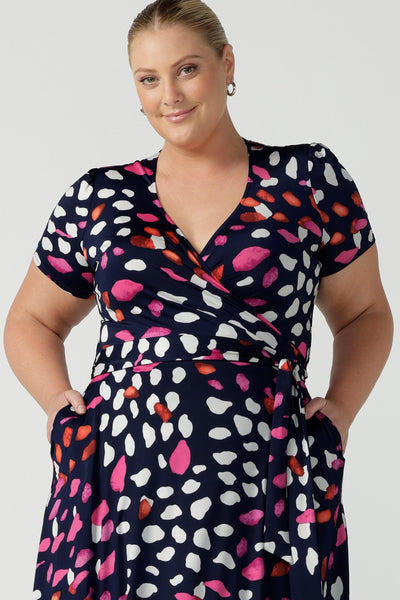 Close up of a curvy, size 18 woman wearing an abstract jersey print, wrap dress with short sleeves. A great dress for summer casual wear, or for travel. Shop made in Australia dresses in petite to plus sizes online at Australian fashion brand, Leina & Fleur.