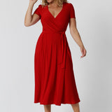 40 year old woman wears red wrap dress crafted from soft dry touch jersey fabric, making it both comfortable and stylish. Midi length dress, it’s perfect for any occasion, especially during the festive season when red is the standout colour. Fashion brand Leina & Fleur stock sizes 8-24.