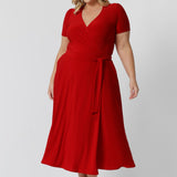 Plus sized woman wears midi length red dress with functioning tie in the front. This stunning wrap dress is crafted from a soft, dry touch jersey fabric, making it both comfortable and stylish. With its elegant midi length, it’s perfect for any occasion. Designed and made in Australia, this versatile dress is available in sizes 8 to 24, ensuring a flattering fit for everyone. Whether you're attending a holiday party or a casual gathering. 