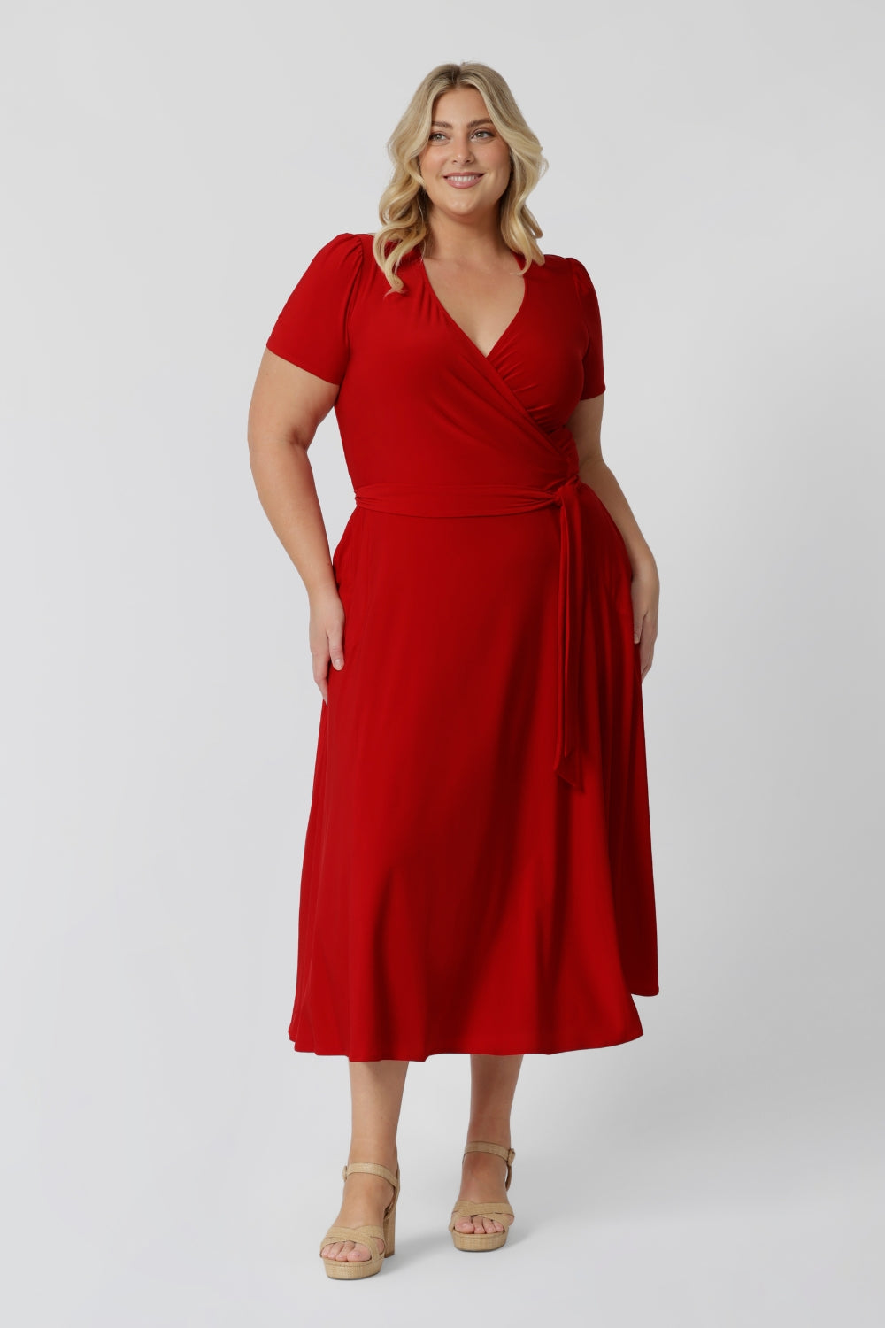 Plus sized woman wears midi length dress perfect for any occasion. Get festive season ready with this red wrap dress. Made in Australia, this party ready dress is available in sizes 8 - 24, ensuring a flattering fit for everyone. Leina & Fleur Fashion brand proudly stocks petite and plus sized friendly clothing.