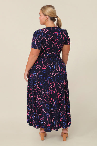 Back view of a petite height, size 16 woman wearing a good midi length dress. The Alexis Dress in Silhouette is a functioning wrap dress, great for an occasion. This women’s dress is made in Australia in sizes 8 to 24.