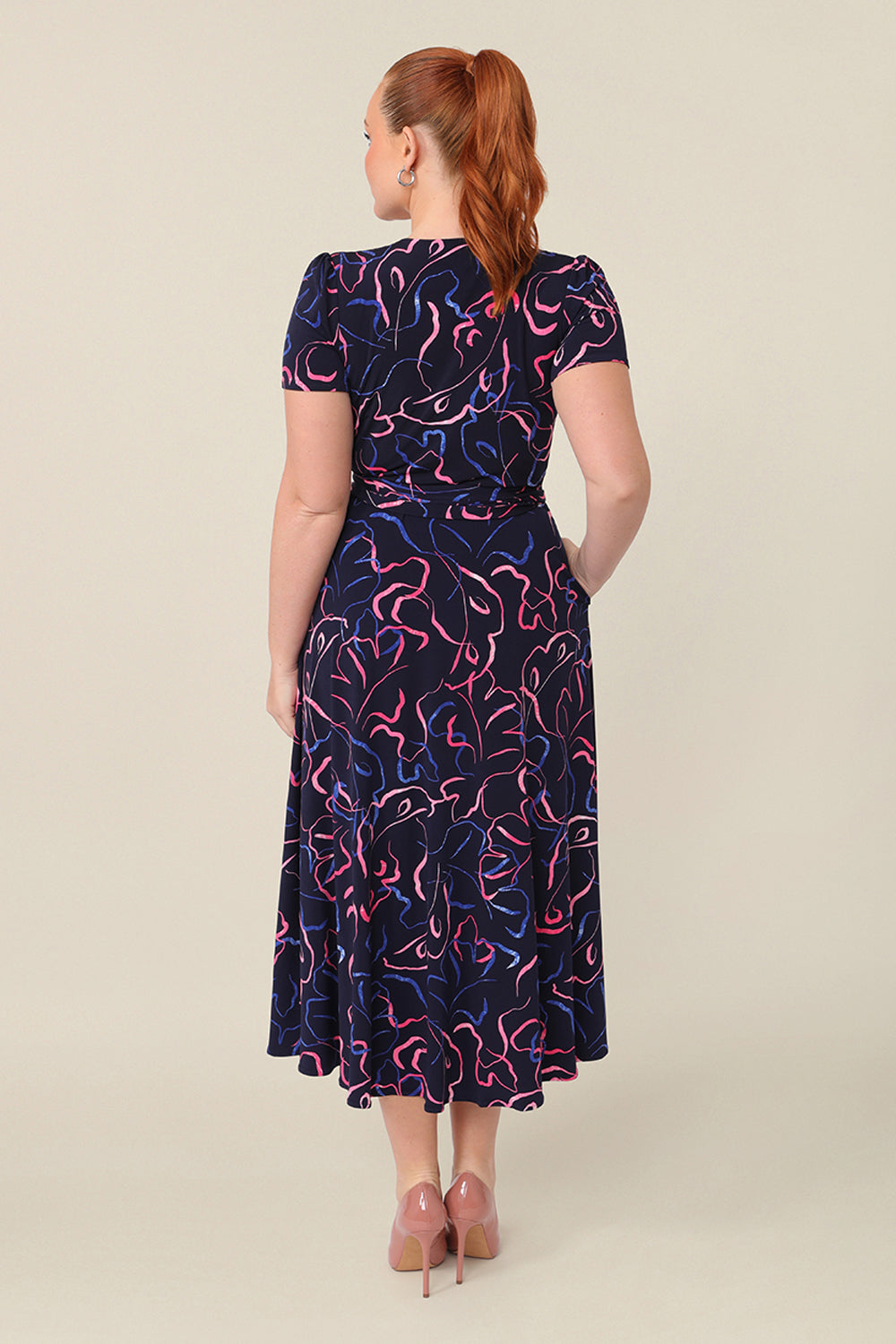 Back view of an Australian-made, printed jersey, wrap dress with short sleeves. A great weekend dress, this wrap dress is styled with heels as an elegant event dress.