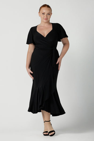 Size 12 woman wears a Alita dress in black. An elegant wrap dress with a tier and sweetheart neckline and flutter sleeve. Made in Australia for women size 8 - 24. 