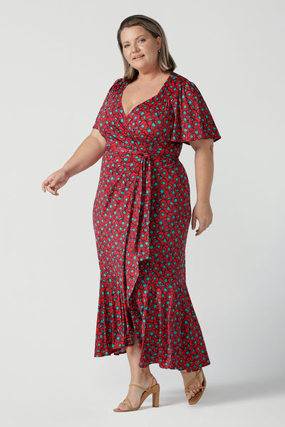 Curvy woman wearing a size 18 woman wearing a wrap dress in soft slinky jersey. The beautiful Rio print has seventies inspired florals with aqua.Romantic valentines day dressing, frill hem and flutter sleeve for curvy women size 8 - 24.