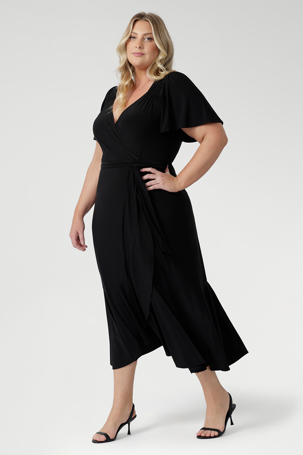 Elegant slinky black wrap dress with flutter sleeves, ruched bodice, and flowing ruffle skirt, Alita by L+F.