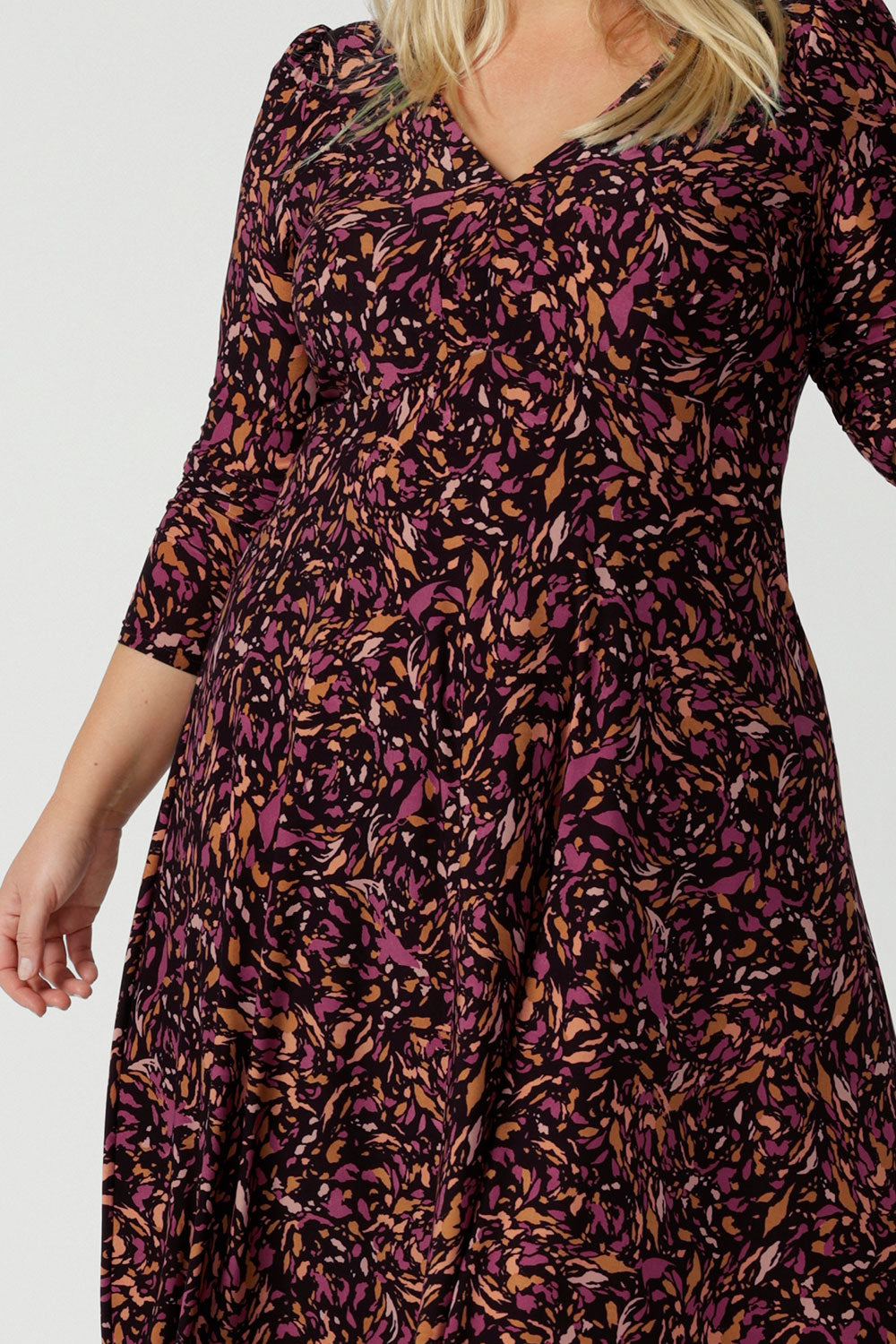 Close up of a size 18 woman wears the Alyssa dress in jersey. A high empire line style with a knee length design and ruched sleeve. Plus to petite size clothing made in Australia for women size 8 - 24