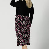 Back view of the Thom top in Black Andi Midi Skirt in Alula in a size 18 is a midi length skirt with the Alula print. Made in Australia style. Styled back with the Thom Top in black 8 - 24.