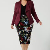 A size 18 woman wears the Lyndon Jacket Midi Skirt back with the Lyndon Jacket in wine.  Made in Australia for women size 8 - 24.