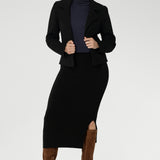The Andi Midi Skirt in Black is designed in a sophisticated mid-calf length with a flattering side-split, making it perfect for both work and events. Crafted as a double-layer tube skirt, it features a soft folded waistband and a comfortable pull-on style, combining elegance with ease of wear.