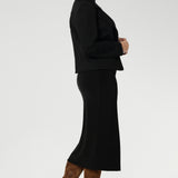 The Andi Midi Skirt in Black is designed in a sophisticated mid-calf length with a flattering side-split, making it perfect for both work and events. Crafted as a double-layer tube skirt, it features a soft folded waistband and a comfortable pull-on style, combining elegance with ease of wear.