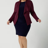 Size 18 woman wears the Navy Mason top in Navy dry touch jersey. Made in Australia for women size 8 -24. Long sleeve and round neckline. Styled back with the Andi skirt in navy and Lyndon jacket in wine. 