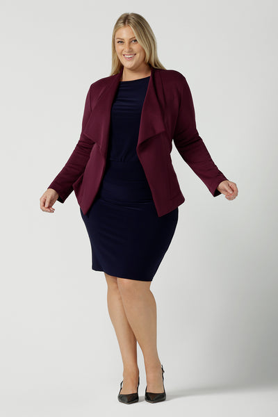 Size 18 woman wears the Navy Mason top in Navy dry touch jersey. Made in Australia for women size 8 -24. Long sleeve and round neckline. Styled back with the Andi skirt in navy and Lyndon jacket in wine. 