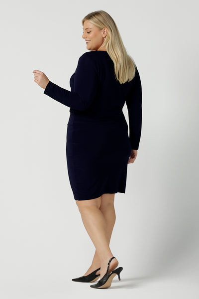 Back view of a Size 18 woman wears the Navy Mason top in Navy dry touch jersey. Made in Australia for women size 8 -24. Long sleeve and round neckline. Styled back with the Andi skirt in navy.