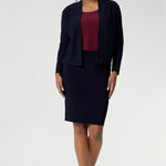The Andi Tube Skirt is available in a mini, regular and midi length for a bold and stylish look no matter your style. Size 10 woman wears her navy tube skirt with matching jacardi in navy & ruby Top.