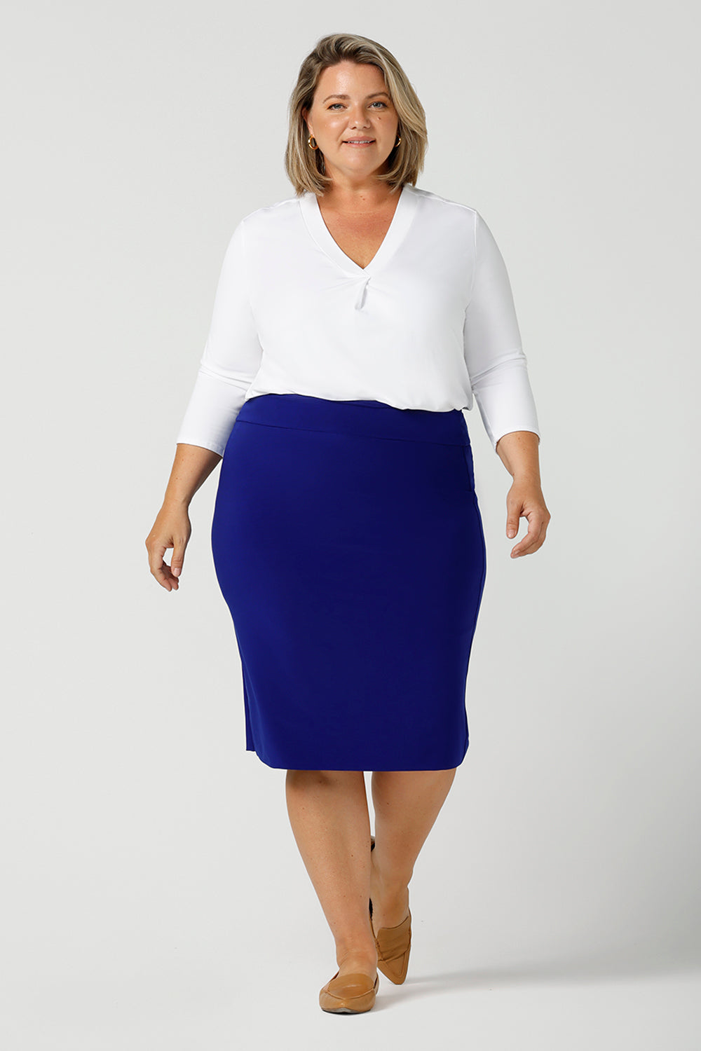 A good white top for your capsule wardrobe, this V-neck , 3/4 sleeve top is made in luxurious white bamboo jersey. Worn with a cobalt blue tube skirt and shown on a size 18, plus size woman, this classic top makes a great work blouse. Made in Australia by Australian andNew Zealand women's clothing brand, Leina & Fleur, this white jersey top is available to shop online in sizes 8 to 24.