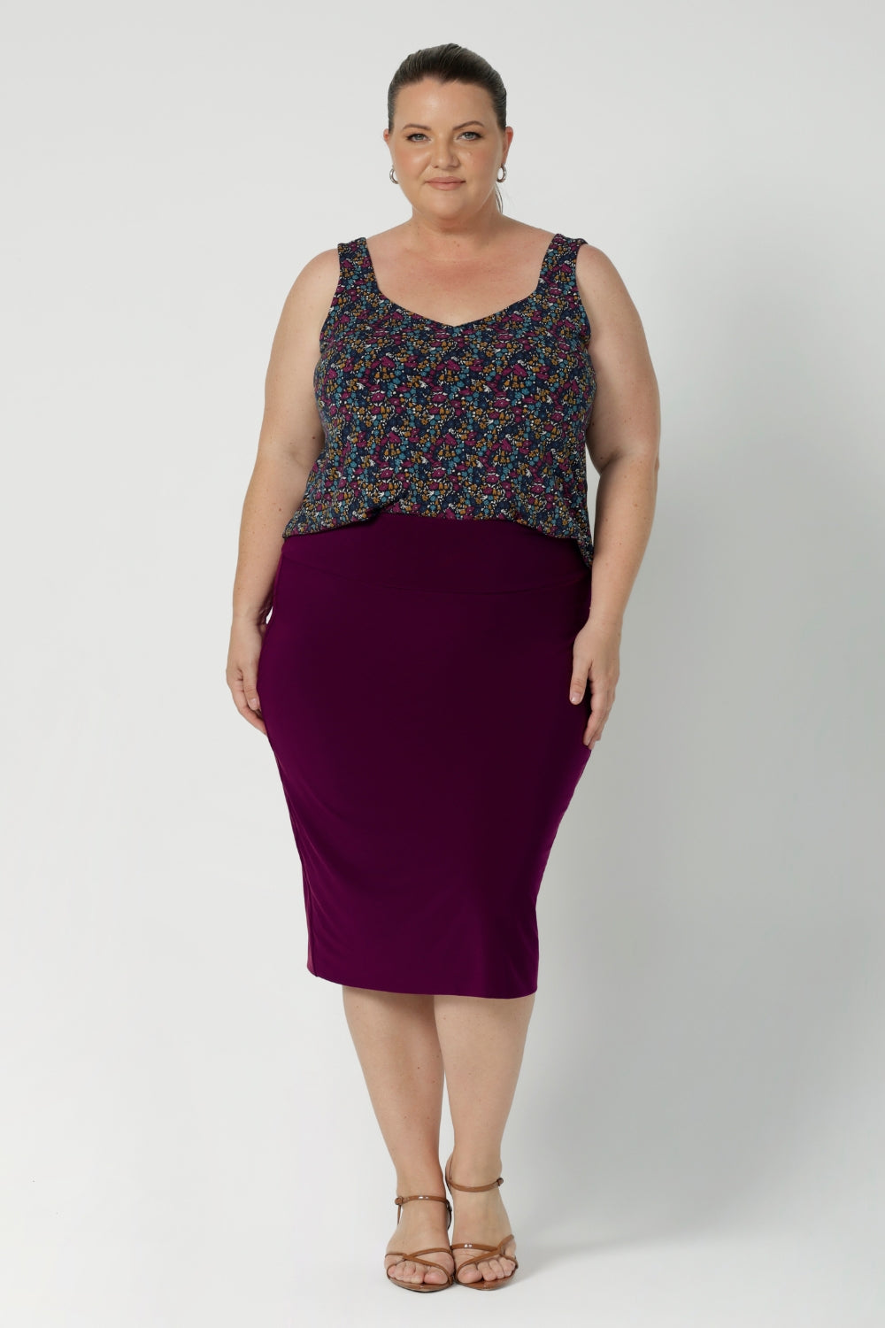 Plus size woman wears magenta coloured tube skirt, paired with summer cami and brown kitten heel. Stretchy tube skirt is made from lux dry touch jersey fabric and provides full body stretch. Available in sizes 8-24.