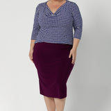 A size 18 woman wears the Andi skirt in Magenta. A made in Australia skirt styled back with Kyrie Top in Polka Dot. Size 8 - 24.