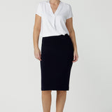 A good navy skirt for women's workwear, this stretch jersey tube skirt moulds to the curves. Great as an office skirt, this navy knee length pull-on skirt is worn with a V-neck white bamboo jersey top with short sleeves.