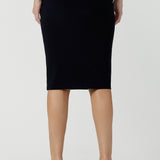 Back view of a good navy skirt for women's workwear, this stretch jersey tube skirt moulds to the curves. Great as an office skirt, this black knee length pull-on skirt is made in Australia by Australian and New Zealand fashion brand, Leina & Fleur. 