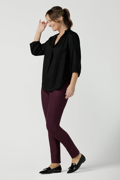 size 10  woman wearing a pull-on black shirt with 3/4. Made in Tencel fabric, the black shirt is lightweight, breathable and eco-conscious. Worn with mulberry pants, this shirt is great for casual wear as well as work. The shirt is Australian made for petite to plus size women.