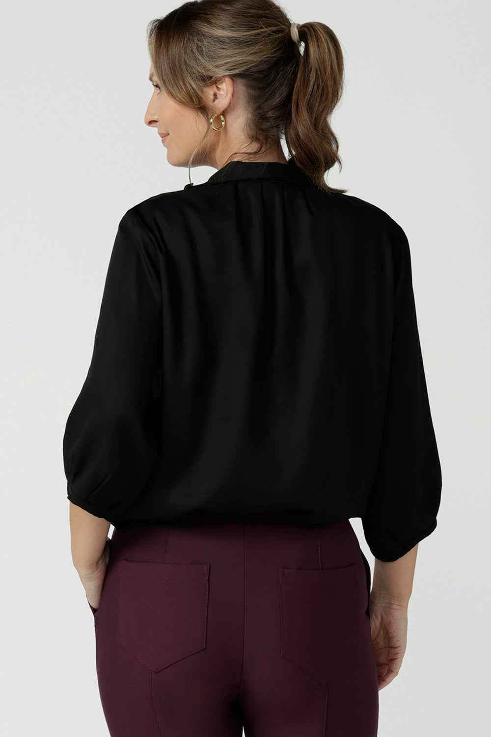 size 10  woman wearing a pull-on black shirt with 3/4. Made in Tencel fabric, the black shirt is lightweight, breathable and eco-conscious. Worn with mulberry pants, this shirt is great for casual wear as well as work. The shirt is Australian made for petite to plus size women.