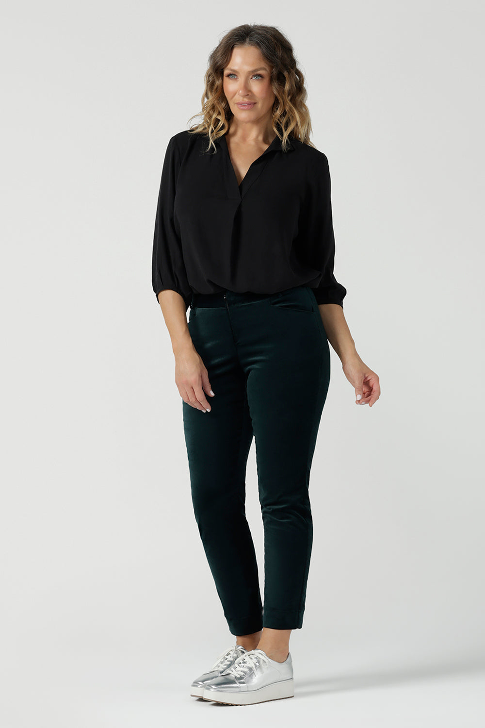 A woman wears the Arley Shirt in Graphite Tencel. A woven shirt with collar and tailored pleat front. Made from sustainable tencel fabric. Made in Australia for women petite to plus size 8-24. Styled back with Velveteen pants.