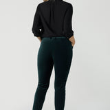 Back view of a woman wears the Arley Shirt in Graphite Tencel. A woven shirt with collar and tailored pleat front. Made from sustainable tencel fabric. Made in Australia for women petite to plus size 8-24. Styled back with Velveteen pants.