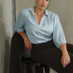 This pull-on style combines a sleek, contemporary silhouette with thoughtful detailing, making it a go-to piece for effortless polish. Semi-fitted through the body, it features a classic collar neckline and subtle tuck details below the back neckline, adding gentle structure without compromising comfort. The ¾ length sleeves fall softly and are finished with narrow bound hems, bringing a refined finish to a relaxed shape. A curved shirttail hemline completes the look.