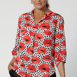 Made from eco-friendly Tencel twill, the fabric has a luxurious drape and smooth feel, with vibrant Povot design in white adorned with poppy details in red, tangerine, and black—adding a pop of colour while keeping the overall aesthetic refined. Though the fabric has no stretch, its beautiful drape creates a flattering, comfortable fit. Seen on over 40's model that wears her woven shirt with black linen pants in size 12. The Arley Shirt can be purchased in sizes 8-24.