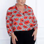 The Arley Shirt in Pavot is the perfect blend of modern elegance and effortless chic, designed to seamlessly transition between work and weekend. Featuring a buttonless, pull on design. Plus size woman wears workwear shirt in size 18 matched with black pants to match back with the print details. 