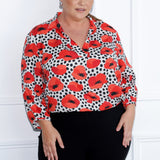 The Arley Shirt in Pavot is the perfect blend of modern elegance and effortless chic, designed to seamlessly transition between work and weekend. Featuring a buttonless, pull on design. Plus size woman wears workwear shirt in size 18 matched with black pants to match back with the print details. 