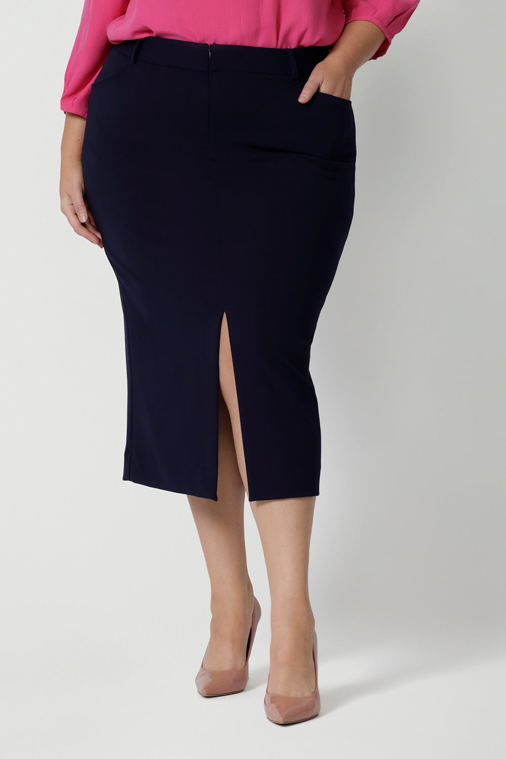 Close up shot of plus-sized model wearing navy work skirt. Midi length skirt pairs perfect with many different colours for corporate or office settings. Easy care fabric scube crepe jersey. This workwear skirt is Australian made by women in Australia and New Zealand. Leina & Fleur is a women’s retail brand that proudly stocks sizes from 8-24. Shop this navy 3/4 skirt in petite and plus sizes.