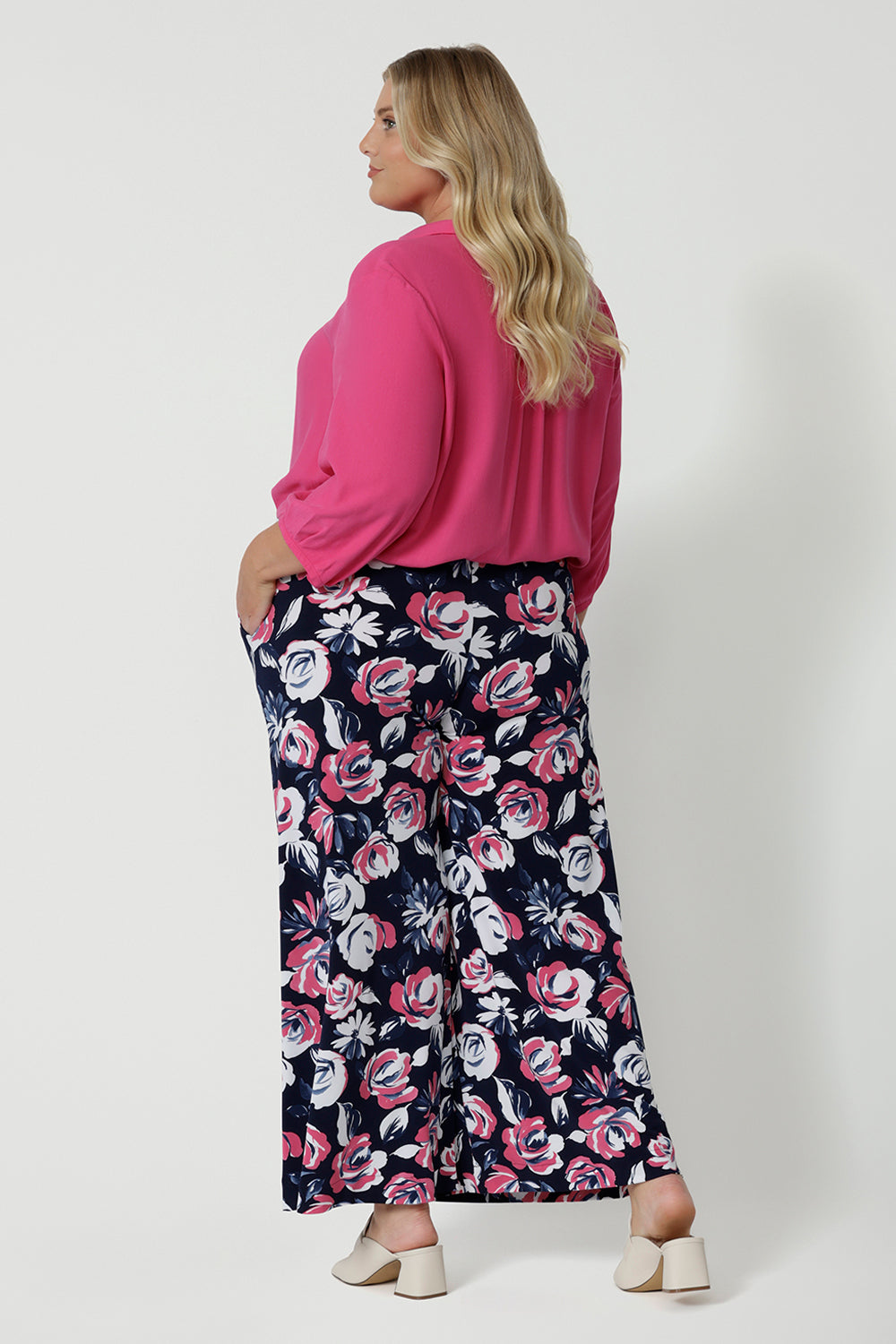 Back view of plus sized model wearing a breathable fabric pant made of dry touch jersey fabric. Floral pattern pant has many colours such as white, pink and navy. This comfortable work wear pant is great for both casual and dressy wear. These easy care pants are made in Australia by Australian and New Zealand women. Leina & Fleur is a woman’s fashion label that stocks sizes from 8 to 24. Shop this comfortable pant in plus size and petite sizes now.