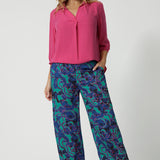 Full body image of an over 40 year old woman wearing a pink tencel fabric shirt with 3/4 length sleeves tucked into a patterned pant. This collared shirt is made from tencel fabric made in Australia by Australian and New Zealand women. Woman’s clothing brand Leina & Fleur proudly stock sizes from 8 to 24 including plus sizes and petite sizes for all. 