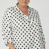 This white soft-touch blouse with black spots is the perfect combination of style and practicality for a woman on the go. Size 18 woman wears lightweight, blouse made from luxurious tencel viscose fabric that feel gentle and lightweight against the skin. Offering all-day comfort, making it ideal for busy days.