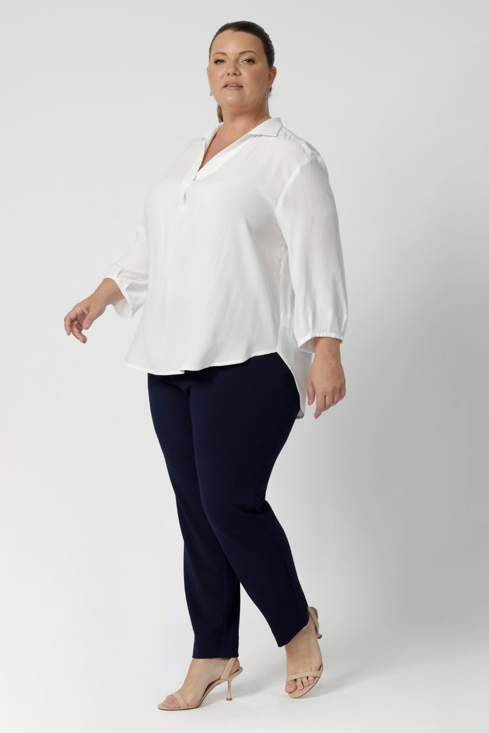 Plus size woman wears Vanilla workwear shirt. A soft tailored shirt with 3/4 sleeves, collar neckline and shirttail hem. Pull on style shirt is made in Australia from sustainable Tencel fabric. Easy care workwear blouse for women, available in 8-24.