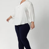 Plus size woman wears Vanilla workwear shirt. A soft tailored shirt with 3/4 sleeves, collar neckline and shirttail hem. Pull on style shirt is made in Australia from sustainable Tencel fabric. Easy care workwear blouse for women, available in 8-24.