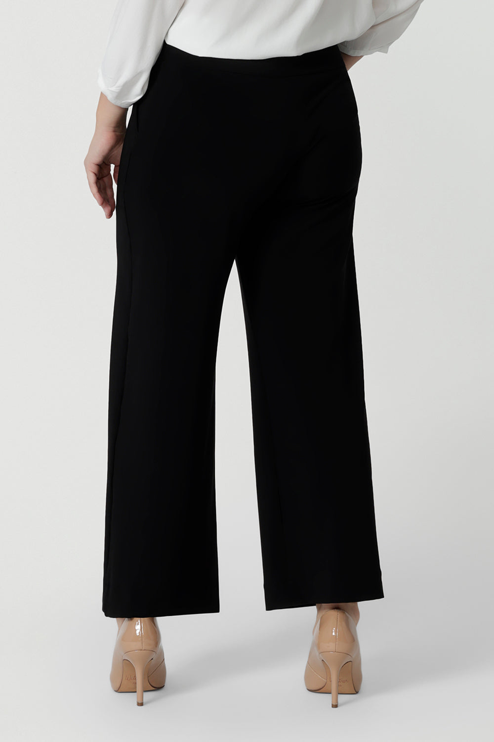 A petite height woman wears black work pants in petite length with a white tencel shirt. Great pants for short women, these Australian-made pull-on trousers are available in sizes 8 to 24, petite to plus sizes.