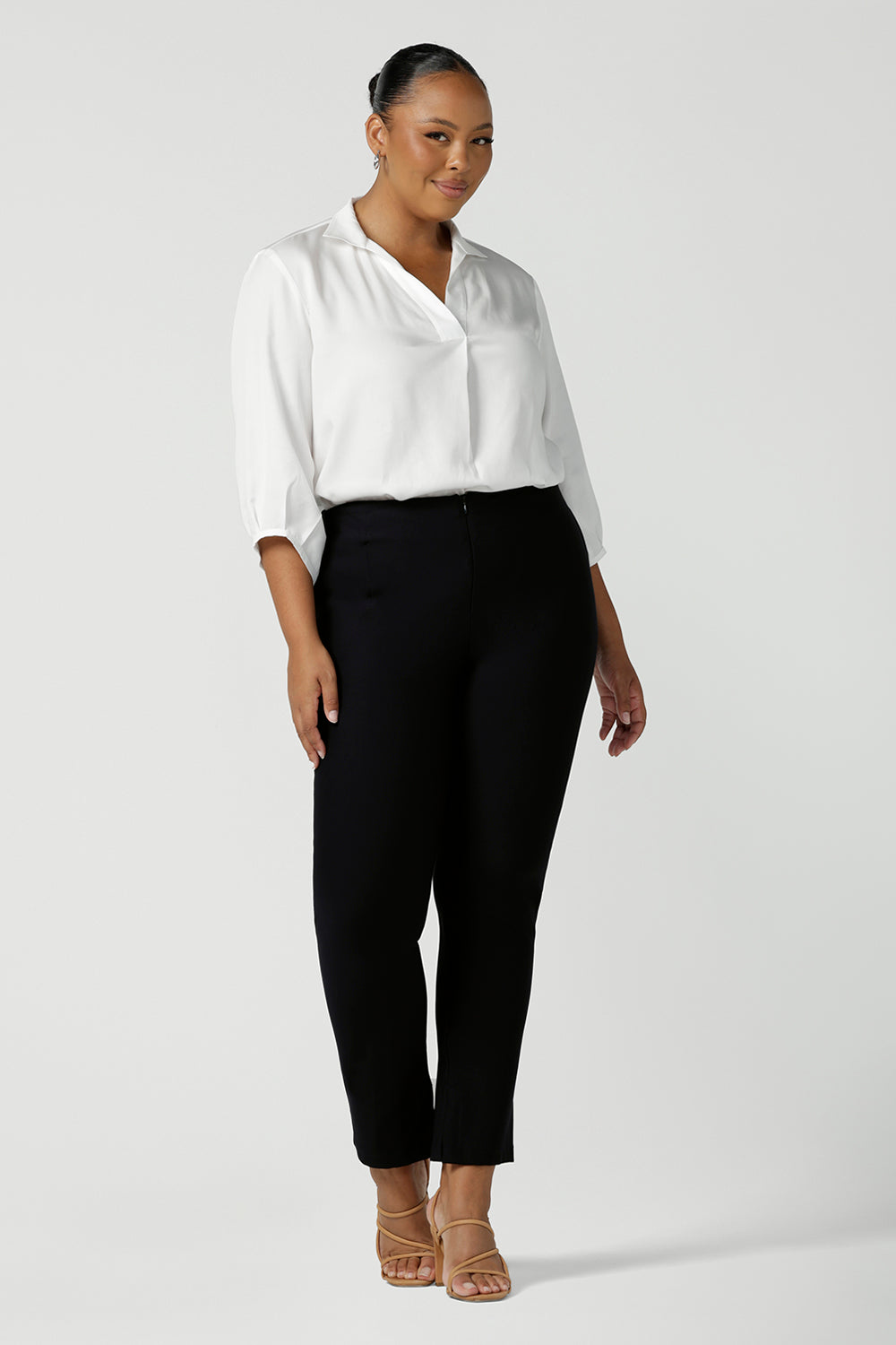 size 18 curvy woman wearing a pull-on white shirt with 3/4 sleeves in eco-friendly Tencel. The shirt is worn with black trousers for a classic work wear look. This white shirt is made in Australia for petite to plus size women.