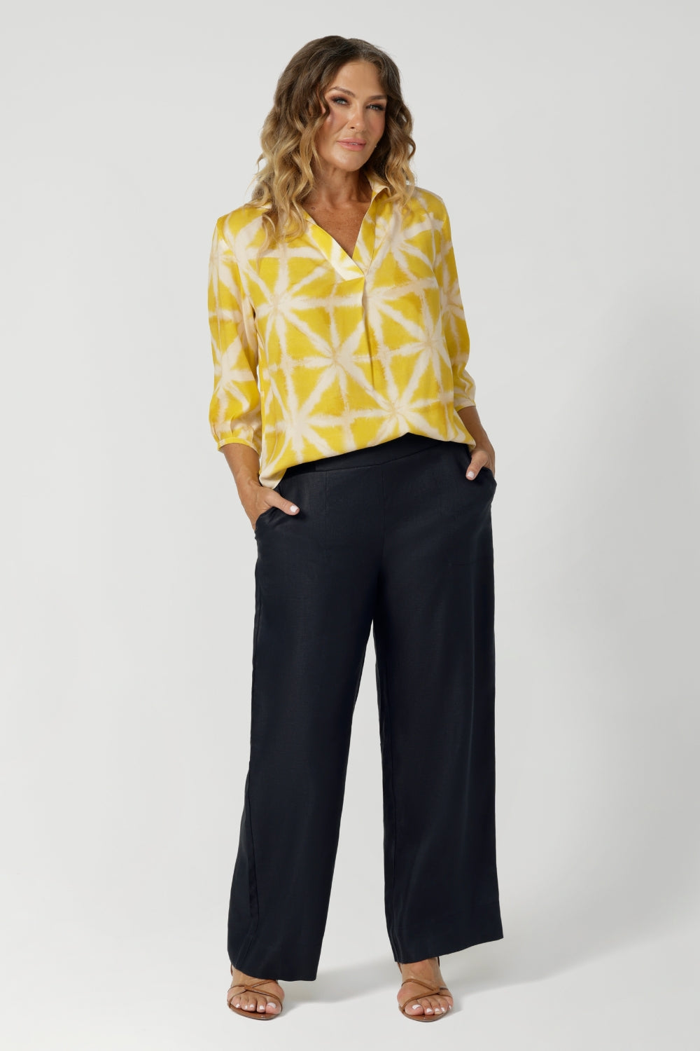 Crafted from a lightweight and sustainable tencel viscose fabric, it offers a luxuriously smooth feel against the skin, ensuring comfort throughout the day. This yellow workwear top is proudly stocked by Leina & Fleur in sizes 8-24.