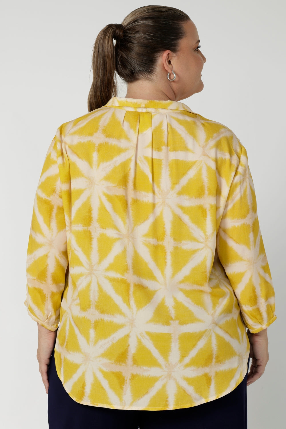 Back image of plus sized woman wearing yellow collard shirt. This pull-on style makes it easy to wear, while the semi-fitted silhouette creates a flattering shape without being too tight. Fabric has no stretch. Arley can be purchased in sizes 8-24.