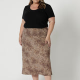 Plus sized model wears animal print skirt paired with a simple black, bamboo top and a black sandal for an every day look or easy travel outfit. This skirt is sure to add a touch of fun and flair to any wardrobe. Crafted by Australian brand  Leina & Fleur, this midi skirt is proudly stocked in sizes 8-24