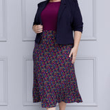 Size 18 woman wears workwear midi skirt paired with magenta top and navy jacket for an elevated workwear look. Crafted on floral dry touch fabric, this skirt features a bias-cut design that drapes beautifully, creating a flattering, easy fluid silhouette. Available in sizes 8-24.