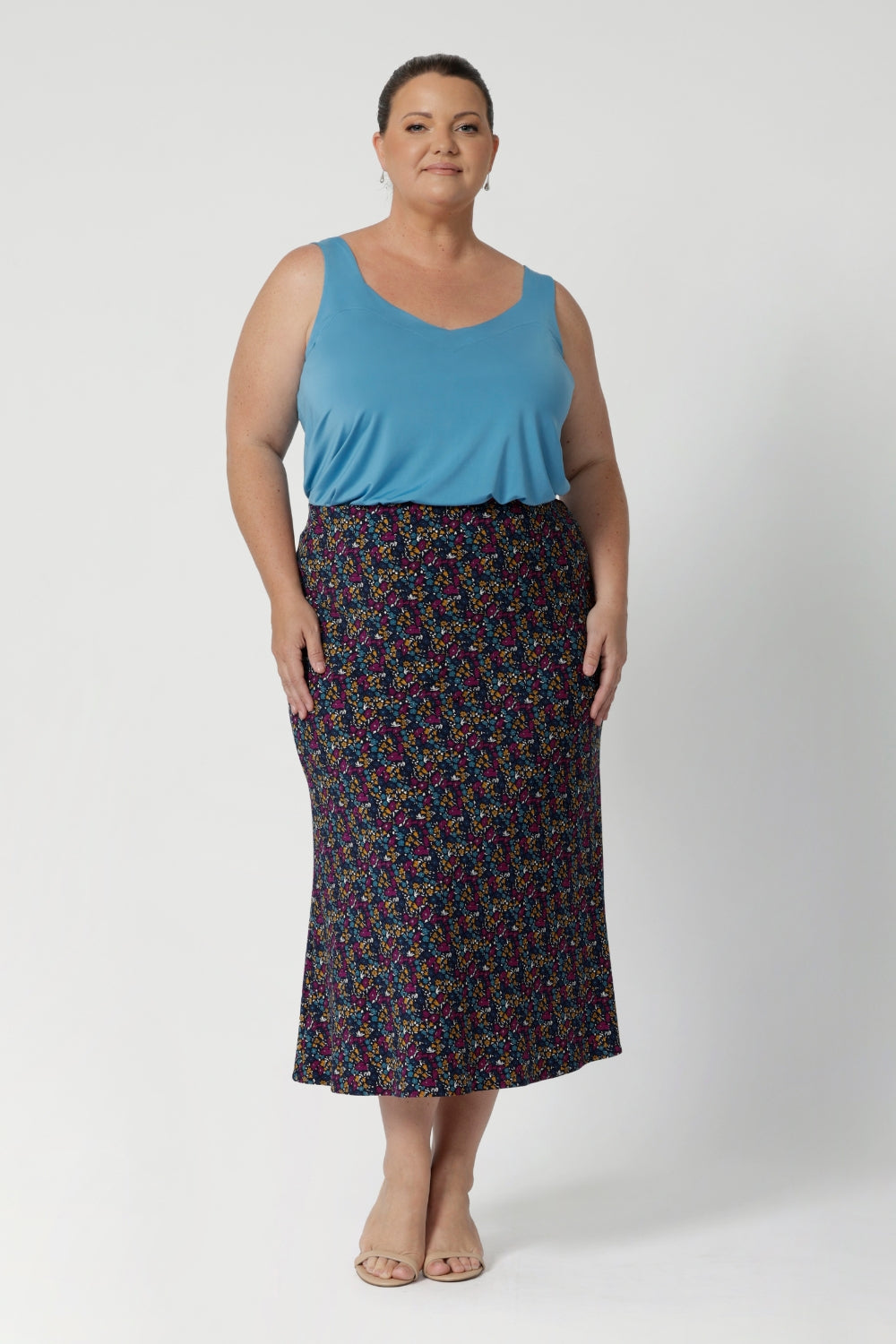 The midi length offers versatility, falling just below the knee to create a polished, refined appearance that's perfect for professional settings or travel. Size 18 woman pairs her Asher Skirt in Harmony with summer ready cami and nude shoe.