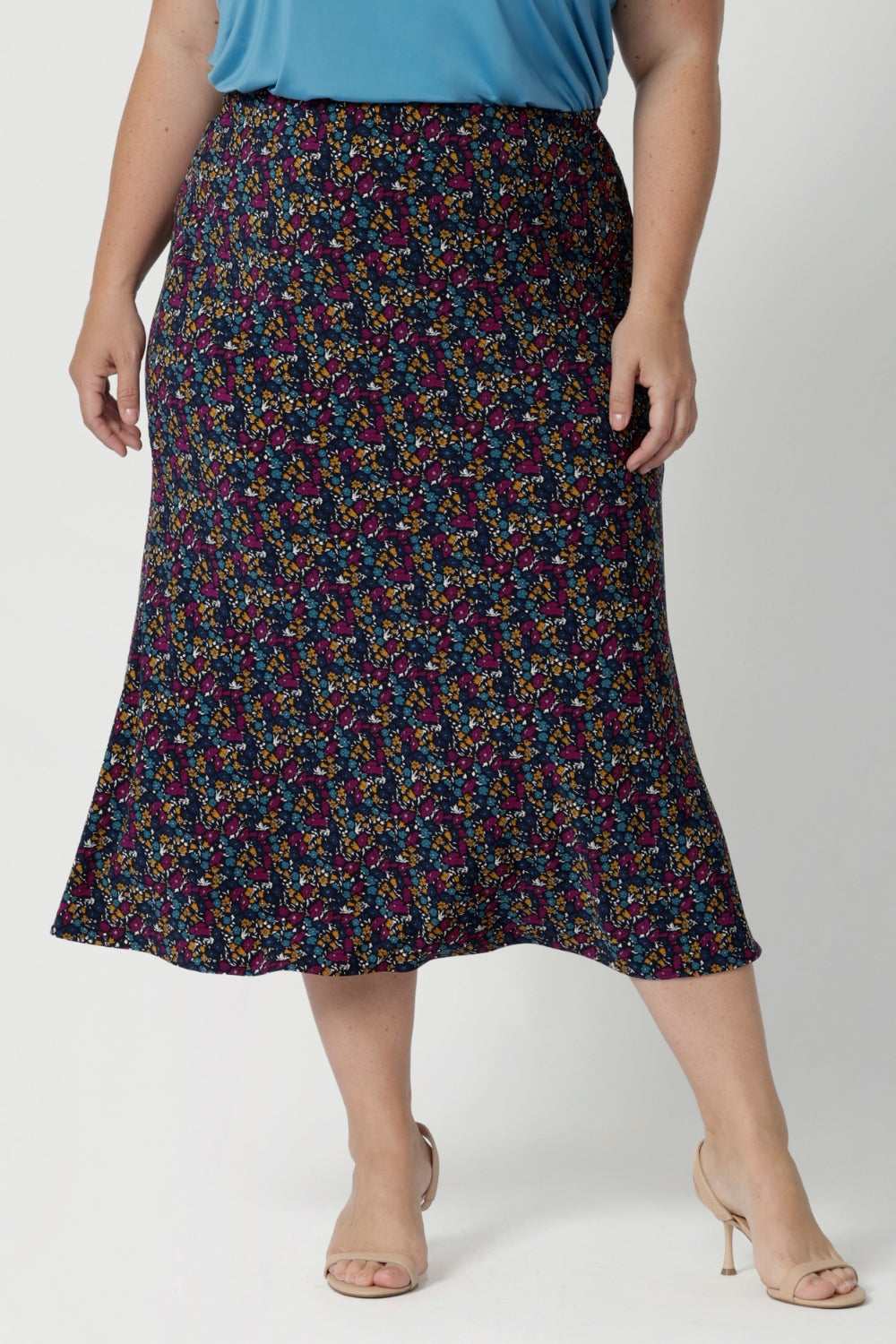 This Australian-made midi skirt is crafted from dry touch jersey fabric, offering a lightweight feel that's perfect for all-day comfort. Size 18 model wears travel ready skirt in Harmony print that features multi coloured daisies. 