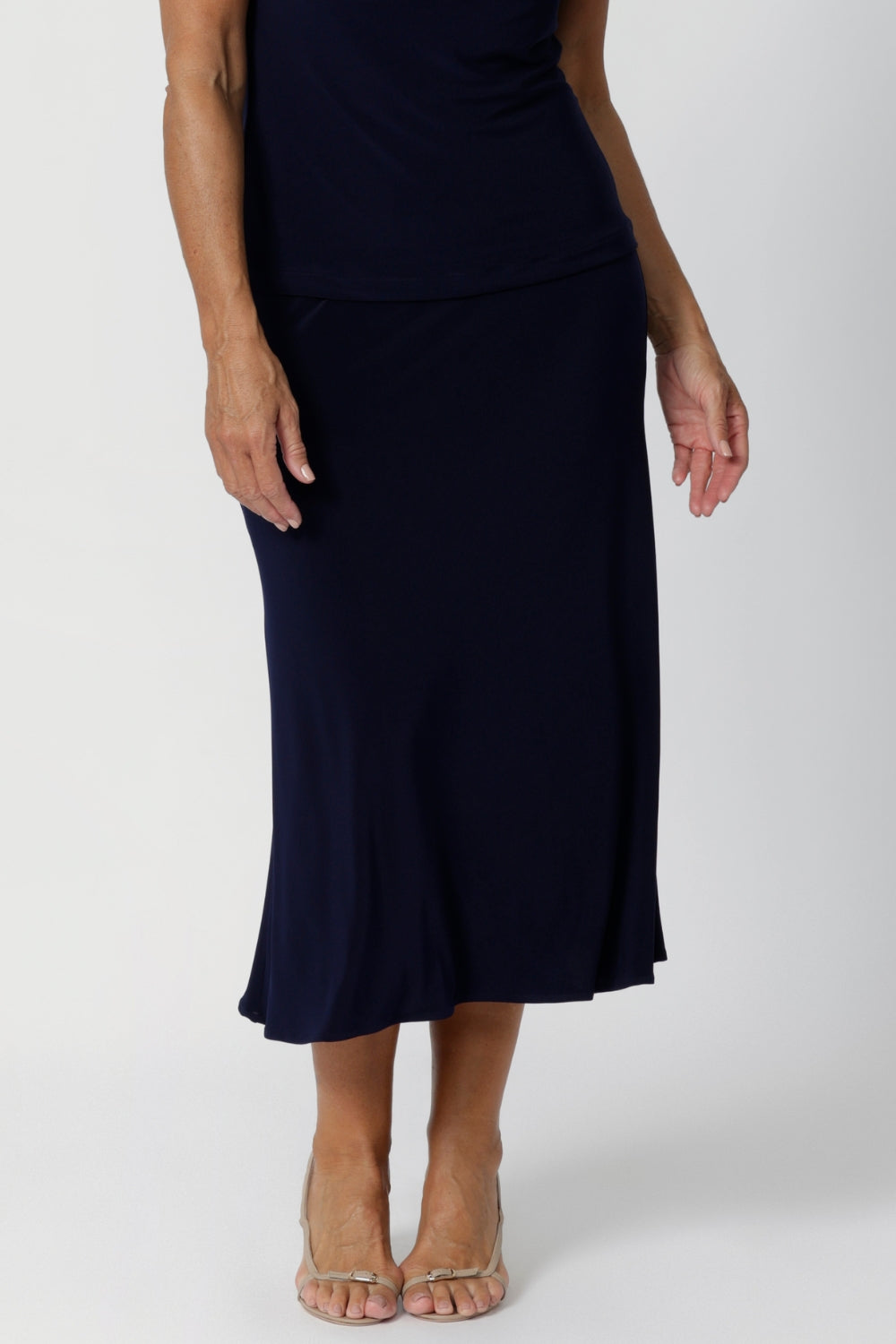 Darts at the back provide shaping, enhancing the natural contours of the body while preserving the A-line shape that gives the skirt its elegant, feminine structure. The midi length offers versatility, falling just below the knee to create a polished, refined appearance that's perfect for professional settings or travel.