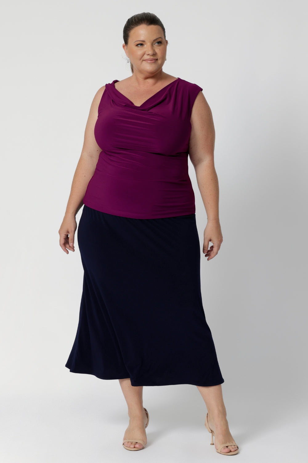 Whether you're dressing for the office or heading out on the go, this skirt serves as a reliable, stylish option that easily pairs with a range of tops, blouses, and jackets. Plus size model wears timeless design in deep blue colour. This Navy Midi Skirt is a versatile wardrobe essential—an ideal piece to keep you looking put-together and confident, wherever the day takes you. Available in size 8-24.